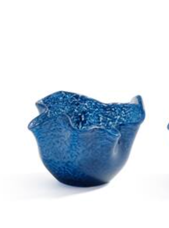 The Zodax Wavy Tealight Holder - Blue is a small, deep blue textured glass piece with wavy, uneven edges like a flower or seashell, shown against a white background.