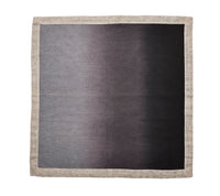 The Kim Seybert Dip Dye Napkins - Earthtones - Set of 4 feature a gradient pattern in earth tones, transitioning from light to dark, and are bordered by a wide beige trim reminiscent of metallic foil details.