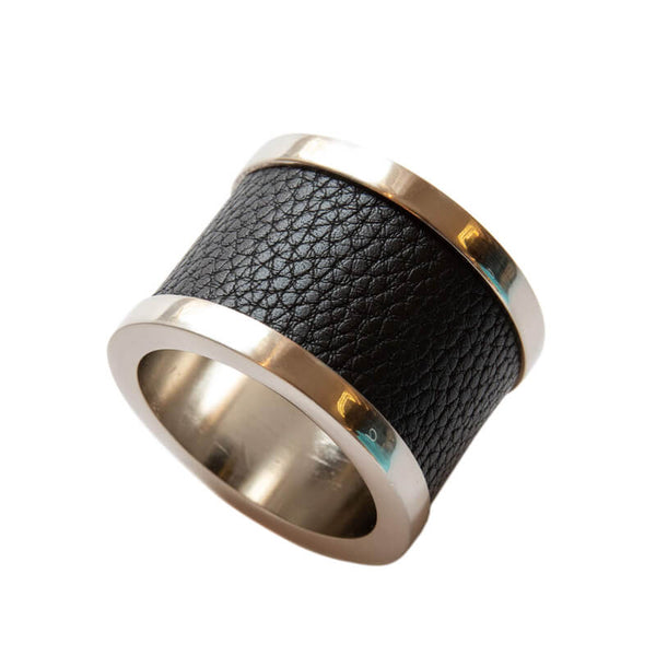 The Von Gern Home Zinc & Leather Napkin Ring S/4 features a wide silver metal ring with a textured black leather band around the center, shown on a white background.