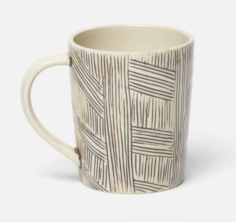The Nolan Dinnerware Black Cream mug by Blue Pheasant features a cream base, black geometric lines, a large handle, and a glossy finish—perfect for artisanal dining.