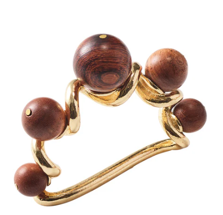 The Kim Seybert Bois Napkin Ring Set of 4 features gold wavy bands adorned with five brown polished wooden beads in varying sizes along the top and sides.