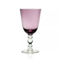 The William Yeoward Fanny Colored Country Goblet 13 oz. features a purple-tinted bowl with a clear, decorative stem and base—ideal for elegant tablescapes and shown against a plain white background.