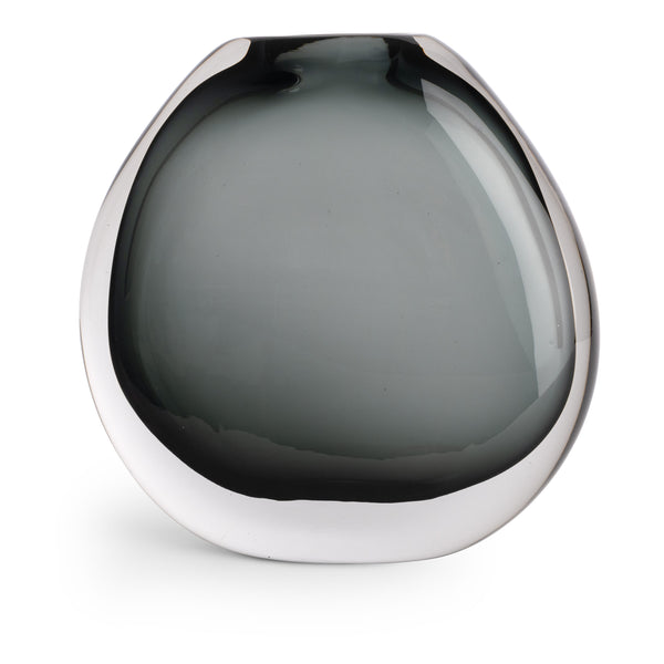 The Nellie Vase by FlowDecor Inc. is a modern, round glass vase with a wide, flat shape and smokey gray tinted glass that fades from dark to light. Its glossy finish makes it a standout piece for contemporary home decor.