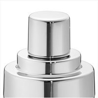A close-up of the Georg Jensen Manhattan Cocktail Shaker's polished nozzle and cap, gleaming on its smooth chrome surface—an elegant barware piece—set against a plain white background.