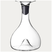 The Georg Jensen Wine & Bar Carafe features clear glass, a modern flared metal spout, and a wide base with an upward-pointing center indentation designed for optimal wine aeration.