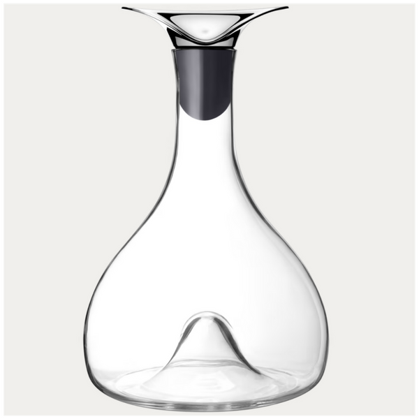 The Georg Jensen Wine & Bar Carafe features clear glass, a modern flared metal spout, and a wide base with an upward-pointing center indentation designed for optimal wine aeration.