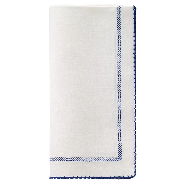 Bodrum Picot Napkin in white with a navy blue zigzag stitched border and a navy blue scalloped hem.