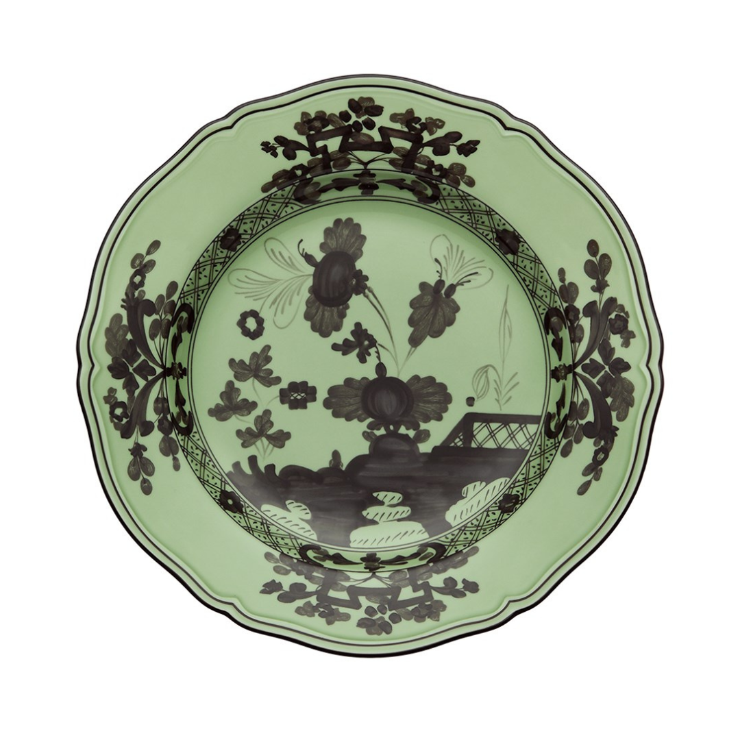 The Oriente Italiano Dinnerware Bario by Ginori 1735 is a decorative green Italian porcelain plate with scalloped edges, showcasing intricate black chinoiserie floral and landscape patterns on the rim and center.
