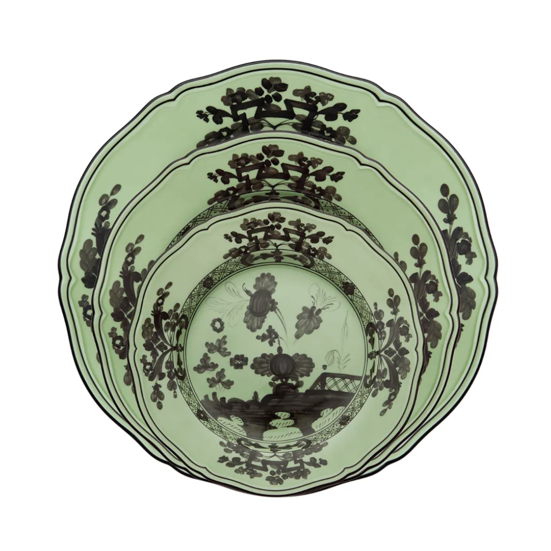 Three green Ginori 1735 Oriente Italiano Dinnerware Bario ceramic plates of varying sizes, each featuring intricate black chinoiserie floral and landscape patterns, are stacked neatly inside one another.