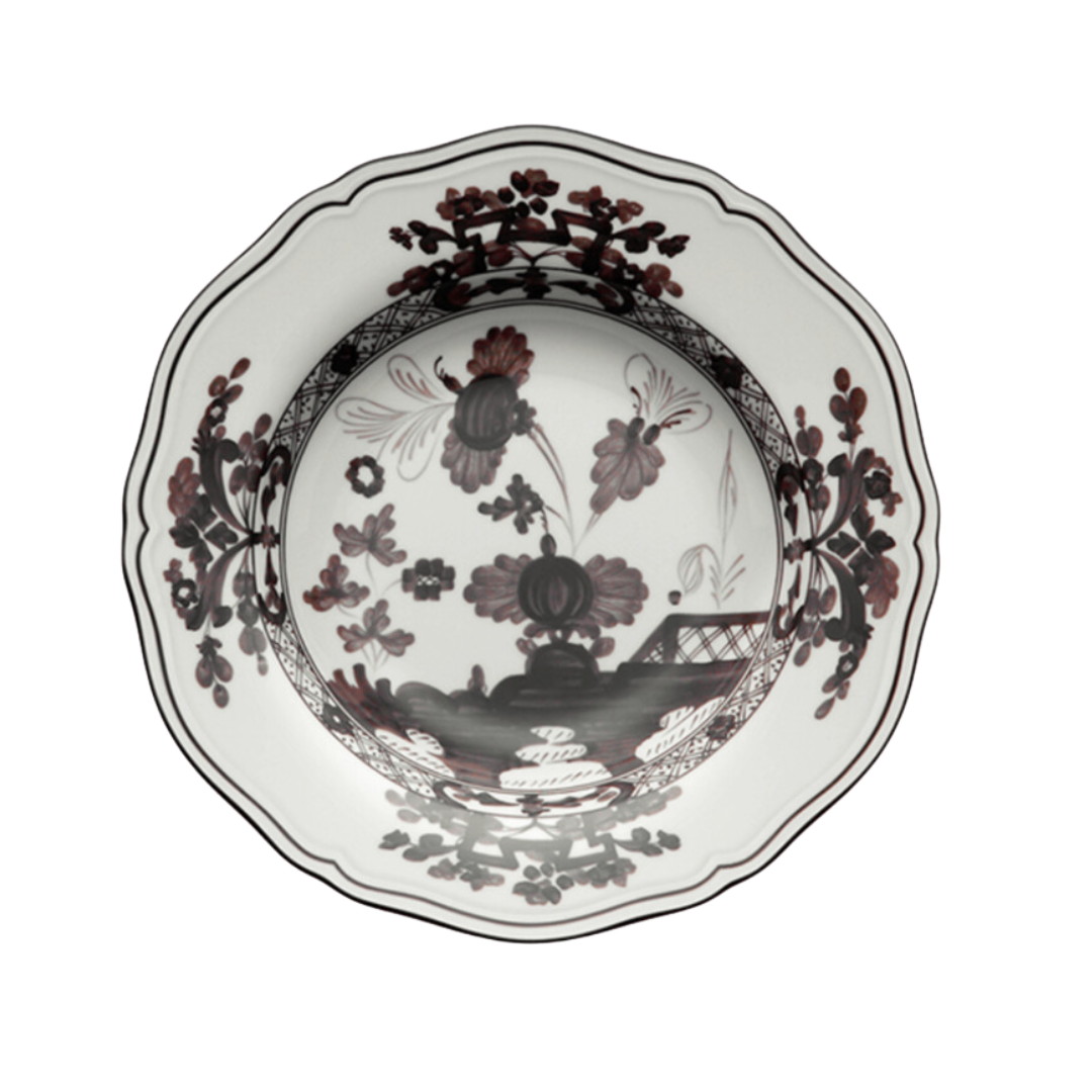 The Oriente Italiano Dinnerware Albus by Ginori 1735 is an Italian porcelain bowl with scalloped edges and a black and maroon floral pattern on a white background.