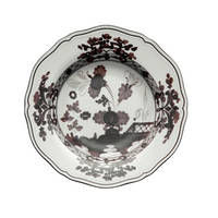 The Oriente Italiano Dinnerware Albus by Ginori 1735 is an Italian porcelain bowl with scalloped edges and a black and maroon floral pattern on a white background.
