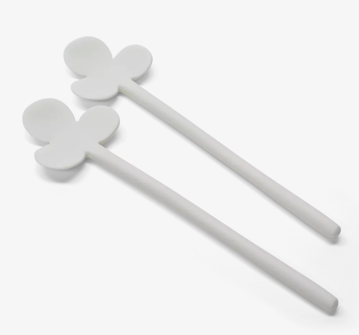 The Fleur Serving Set White by Tina Frey includes two white silicone spatulas, each with a spoon-shaped head and three petal-like extensions, shown against a plain white background.