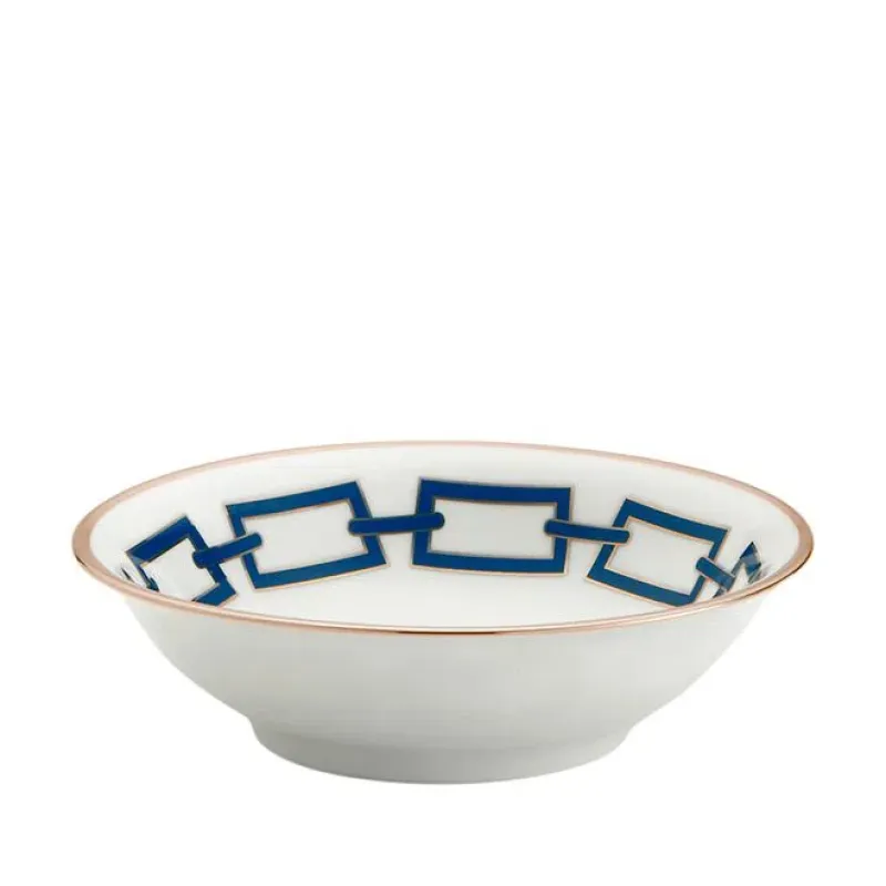 The Catene Zaffiro Dinnerware by Ginori 1735 is a white ceramic bowl featuring a blue chain link pattern and gold rim, inspired by Gio Ponti porcelain and the brand’s geometric porcelain collection.