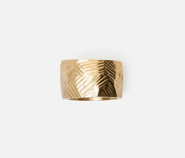 The Gian Napkin Ring s/4 - Gold by Blue Pheasant features a wide, engraved crisscross texture and is shown on a plain white background.