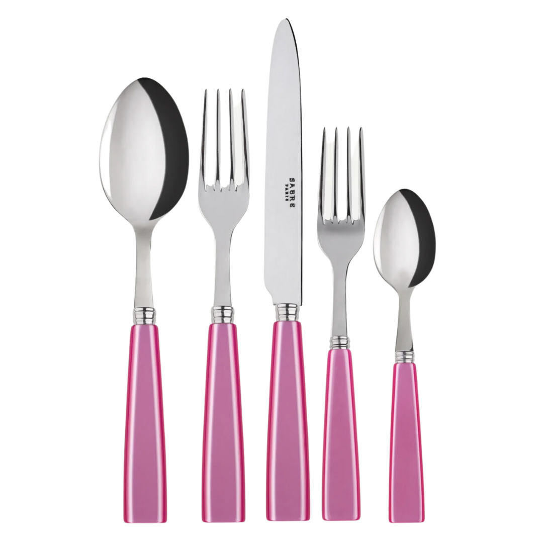 The Sabre Icone Flatware 5 Piece Setting features shiny 18/10 stainless steel and pink handles, including a tablespoon, dinner fork, dinner knife, salad fork, and teaspoon displayed on a white background.