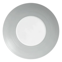 A silver charger plate by JL Coquet, featuring a brushed finish and a white Limoges porcelain center, inspired by the Hemisphere Dinnerware Grey collection.