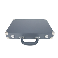 The Brouk & Co Excelsior Backgammon Set is a closed, dark gray briefcase made from vegan leather with silver metal corner protectors, latches, and a sturdy handle, shown against a white background.
