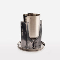 The Artisan Resin Kiddush Cup by CDMX / BRUCI features a modern silver goblet in a grey marbled resin holder, displayed on a silver tray—an elegant example of Mexican craftsmanship.