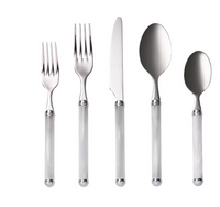 The Kim Seybert Mirage Flatware 5 pc Place Set in White/Silver includes a salad fork, dinner fork, dinner knife, soup spoon, and teaspoon arranged neatly on a white background. This stylish set is also dishwasher safe.