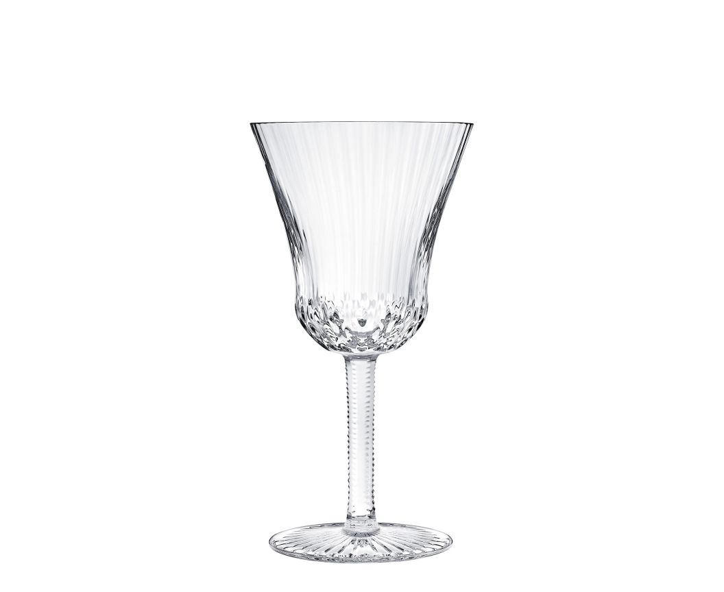The Apollo Stemware by Saint-Louis/Hermes features a fluted bowl, textured stem, and decorative base. This mouthblown, hand-cut crystal wine glass is elegantly displayed on a white background.