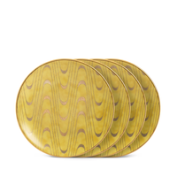 Four oval yellow and gold canape plates by L’Objet, from the Fortuny Apollo collection, feature a glossy wavy gold pattern and slim rims—partially stacked on white for a chic luxury gift box.