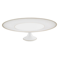 The Oskar Dinnerware cake stand by Raynaud features white Limoges porcelain with a round plate, subtle textured pattern, thin gold rim, and a short pedestal base.