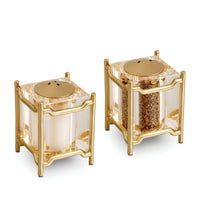 The Han Spice Jewels Set Salt & Pepper by L'Objet features two elegant square shakers with clear sides and 24k gold-plated frames, filled with salt and pepper, beautifully presented in a luxury gift box.