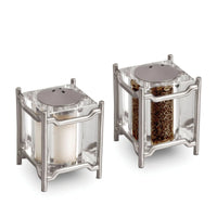 The Han Spice Jewels Set Salt & Pepper by L'Objet features two modern, square salt and pepper shakers with metal frames and tops, presented in a luxury gift box—an elegant addition to any table.