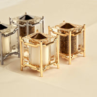 The Han Spice Jewels Set Salt & Pepper by L'Objet features four elegant, cube-shaped shakers with clear glass and 24k gold-plated or silver frames—beautifully arranged for gifting in a luxury box.