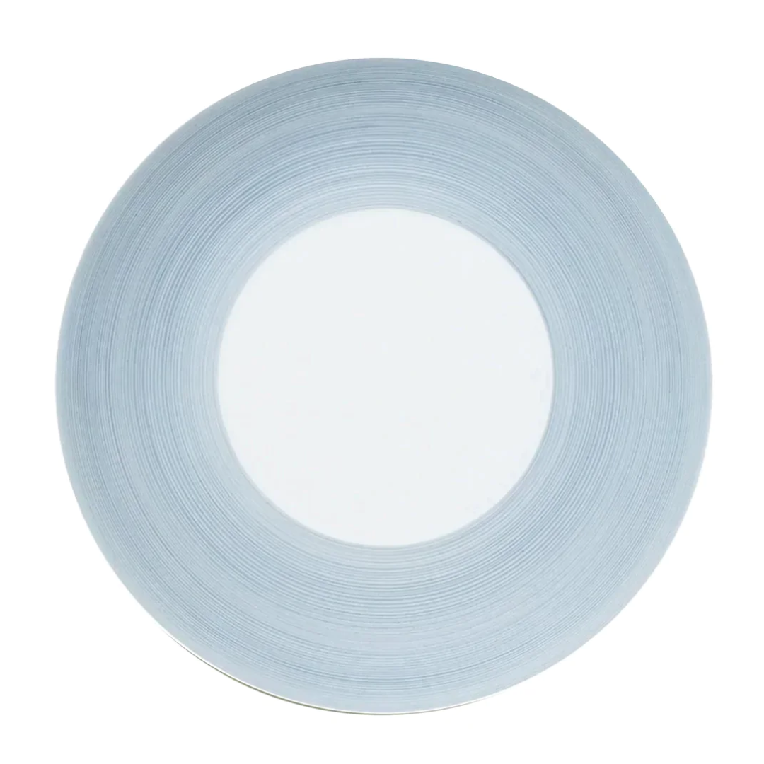 A round plate from JL Coquet's Hemisphere Dinnerware Storm Blue features a wide storm blue textured rim and a smooth white center, shown from above on a white background.