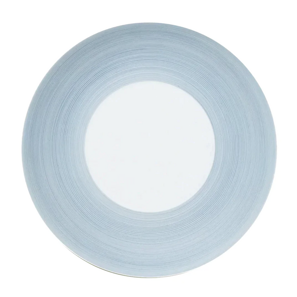 A round plate from JL Coquet's Hemisphere Dinnerware Storm Blue features a wide storm blue textured rim and a smooth white center, shown from above on a white background.