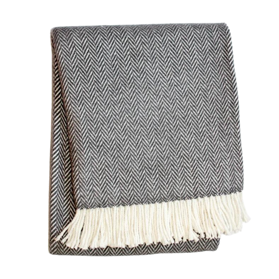 The A Soft Idea Herringbone Plush Throw is a folded dark gray blanket with cream fringe, displayed against a white background—a cozy and stylish accent for any space.