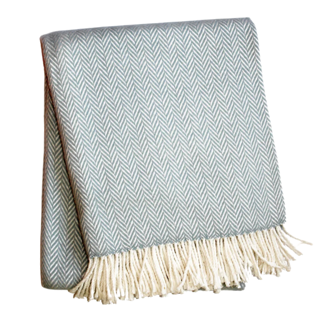 The A Soft Idea Herringbone Plush Throw features folded light blue and white herringbone design with fringed edges. This soft, machine washable blanket is perfect for cozy nights.