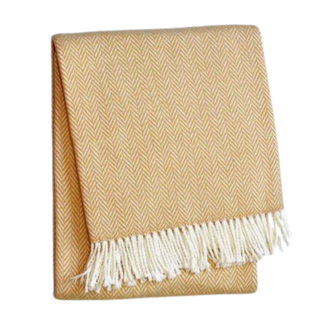 The A Soft Idea Herringbone Plush Throw in mustard yellow features a subtle herringbone pattern and white fringe. This soft, machine washable blanket is folded and shown against a plain white background.