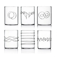 Six Deco Clear Water Glasses by Ichendorf Milano, each made from sturdy borosilicate glass and adorned with distinctive raised patterns—such as loops, waves, rings, parallel lines, and dots—are arranged in two rows on a plain white background.