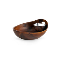 The Portables Chip & Dip by Nambe is a round acacia wood serving bowl with a built-in Nambé Alloy metal dish for sauces, featuring a smooth polished finish and a unique, modern design.