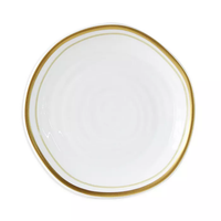 The Albatre Dinnerware - Gold by Bernardaud is a white ceramic plate with a subtly irregular shape and an elegant gold rim—perfect for enhancing any gold-rim plates or alabaster dinnerware collection.
