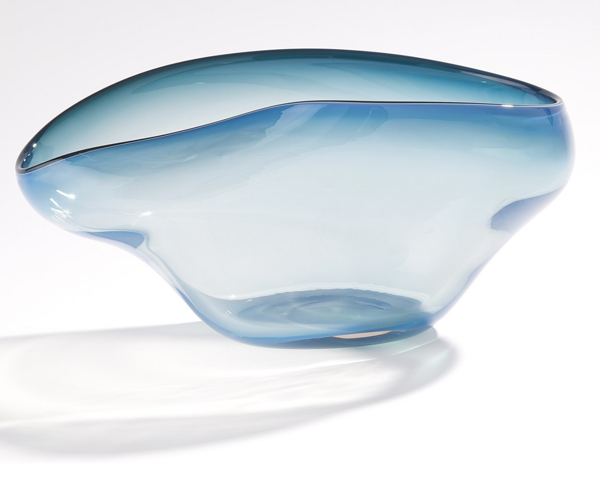 The Harmony Bowl Dark Blue by Global Views / Surya features translucent blue glass with fluid, organic curves and an uneven rim, showcasing a subtle ombré design that casts a soft shadow on any white surface—an exceptionally distinctive serving option for the contemporary table.