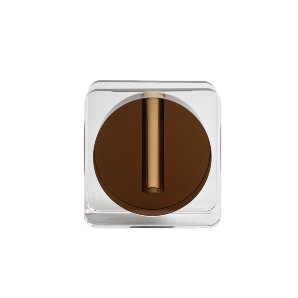 Viewed from above against a white background, the Greg Natale Caldera Crystal Vase - Clear & Umber features a clear square body, a round dark brown lid, and a central vertical gold accent—an elegant sculptural piece.