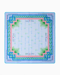 Oh My Mahjong’s “Mahjong Mats -” square scarf features light blue vertical lines, central green palm trees, geometric blue and pink borders, and “JOKERS” and “DRAGONS” printed along the edges.