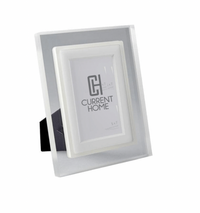 The Prisma Frame Lip - Eggshell by Bella Moulding is a white and silver freestanding acrylic photo frame with a black stand, offering modern protection and elegant display for your 5x7 photos.