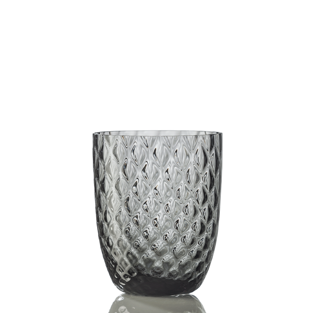 The Idra Grey Ballotin Tumbler by Nason Moretti, with a diamond-textured surface, stands upright on a white background showing a subtle reflection.