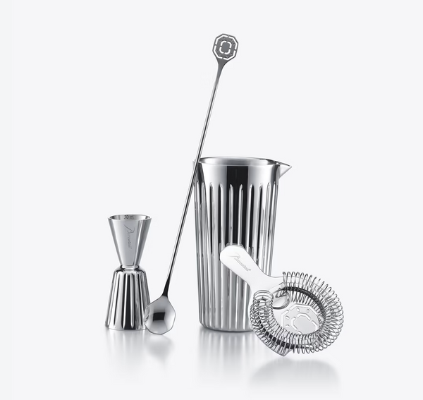 The Harmonie Set of 4 Bar Accessories by Baccarat—featuring a double jigger, mixing glass, long stirring spoon, and strainer—is elegantly arranged upright against a plain white background.