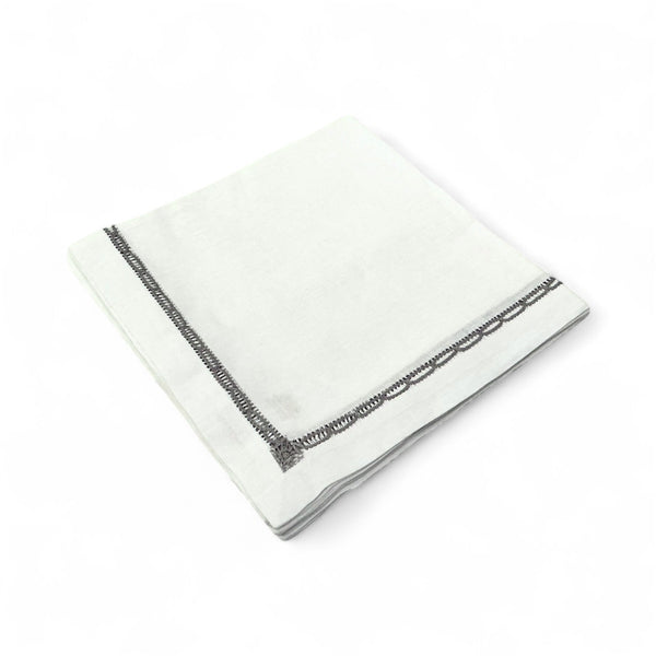A set of four Deborah Rhodes Embroidered Lace Insert Napkins in Dust, neatly folded with detailed lace accents, is shown against a plain white background.