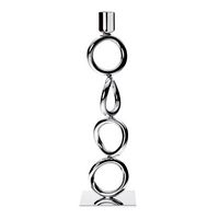 The Christofle Vertigo Silver Plated Candlestick features a modern vertical design with three interlocking rings, a teardrop shape, and a square base—ideal for those who appreciate striking candlesticks.