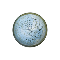 The Nymphea Dinnerware by Jaune De Chrome is a round ceramic plate made in France, featuring a greenish rim and blue-white speckled center, shown from above on a white background.