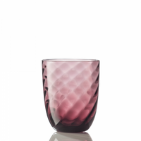 The Idra Tumbler Optic Twist by Nason Moretti, featuring translucent purple glass and a textured wavy pattern, sits on a reflective surface against a plain white background.