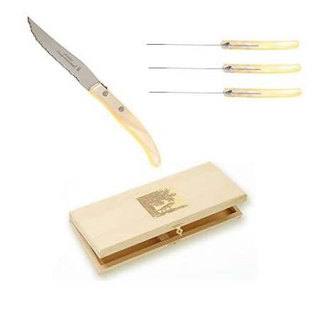 The Berlingot Steak Knives s/6 Assorted by Claude Dozorme are displayed on a white background, featuring six serrated steak knives with light handles and presented in a light wooden box adorned with a gold emblem.