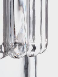 Clear, cylindrical Tom Dixon Press Vase Medium with a vertical, ribbed texture.