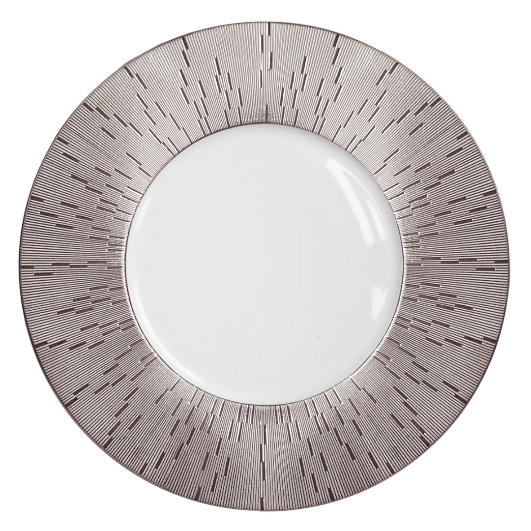 The Infini Prestige Platinum Dinnerware by Haviland features a round white Limoges porcelain plate with a wide, hand-painted rim adorned with thin, dark radial lines and a metallic sheen for an elegant, modern touch.